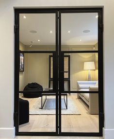 an open glass door leading to a living room with white walls and furniture in the background