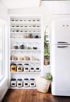 a white refrigerator freezer sitting inside of a kitchen next to a wooden flooring