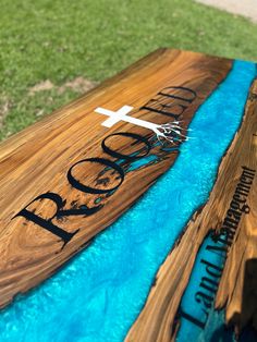 a wooden table with blue water and a cross on the top that says god's love