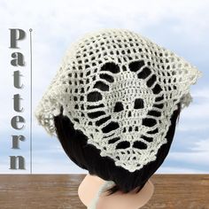 a white crocheted hat on top of a mannequin's head