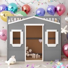 a doll house with balloons and confetti around it