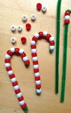 some candy canes are sitting on a table with pins in the shape of letters