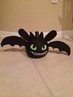 a stuffed toy with green eyes and fangs on it's head sitting on the floor