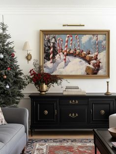 a living room with a christmas tree in the corner and a painting on the wall