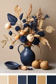 a blue vase filled with lots of flowers next to some eggs and oranges on a table