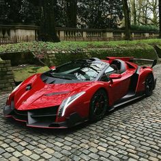 a red sports car parked on top of a brick road