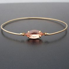 "Peach Bracelet - Peach Jewelry - A vintage soft pastel peach Swarovski Rhinestone in a gold tone brass setting has been transformed into a dainty & delicate peach bangle bracelet with a gold tone brass band. I can also make this soft pastel bracelet with a 14k gold filled band for an additional $10. This peach bangle also available in silver for $12.95, or with a sterling silver band for for an additional $10. This pale peach bracelet looks great stacked together with others from my collect Elegant Peach Bracelet, Adjustable Peach Bracelet, Elegant Peach Bracelet Jewelry, Elegant Adjustable Apricot Jewelry, Elegant Adjustable Peach Jewelry, Peach Bracelet, Peach Bridesmaid, Pastel Bracelet, Pastel Jewelry