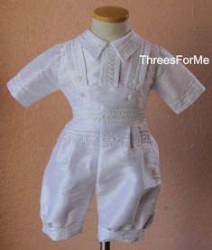 Our cutest little outfit yet. Dress your little one in tradition with our newest Charro outfit design with infants in mind. Our charro outfit comes in a complete set with everything needed to dress him on this big day. The outfit itself is a five piece set. Romper pants are ankle pants, wide fit, quarter sleeve shirt with button closure in back and the top vest is outlined with silver details stitching and a horse shoe decorates the back of the vest with couple rhinestones. Easy clip on ready ma White Sets For First Communion In Summer, White Short Sleeve Wedding Set, White Fitted Short Sleeve Baptism Dress, Fitted Short Sleeve Sets For First Communion, White First Communion Sets For Summer, Classic Short Sleeve Sets For Baptism, White Short Sleeve Formal Sets, White Short Sleeve Set For First Communion, White And Gold Charro Quince Dress