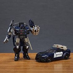 a toy car next to a transformer robot on a table