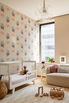 a baby's room with pineapple wallpaper and white furniture