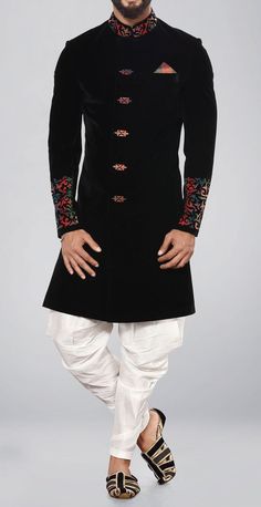 a man in a black sherwa with white pants