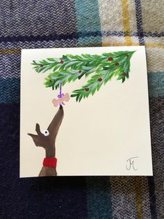 a card with an image of a hand holding a christmas tree