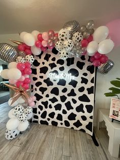 an animal print backdrop with balloons and streamers