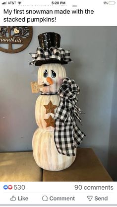 a snowman made with the stacked pumpkins