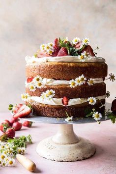 a cake with strawberries and daisies on top