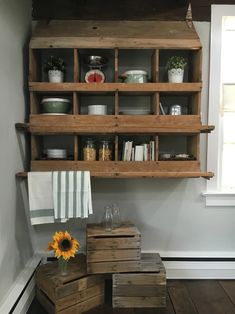 a wooden shelf filled with lots of shelves next to a vase and sunflowers