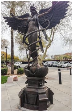 a statue of an angel with a snake wrapped around it's body and wings