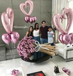 a group of people standing next to each other with balloons in the shape of hearts