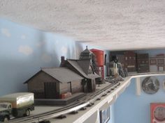 a model train set is on display in a room with blue walls and white ceiling