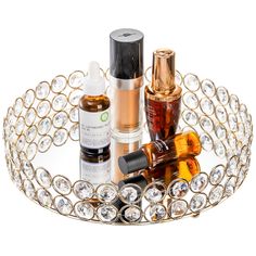 an assortment of beauty products are displayed on a glass tray with gold trimmings