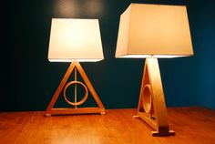 two lamps sitting on top of a wooden table next to each other in front of a blue wall