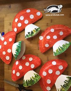 paper plates with trees and mushrooms on them are sitting on a table next to scissors