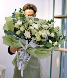 a woman holding a bouquet of white flowers