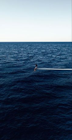 a person on a surfboard in the middle of the ocean with a line attached to it