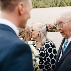 an older man and woman standing next to each other