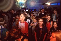 a group of people standing around each other in a room with fireworks on the ceiling