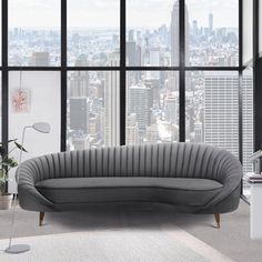 a living room with large windows and a couch in front of a cityscape