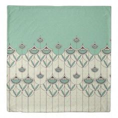 a green and white blanket with an abstract design on the front, along with polka dots