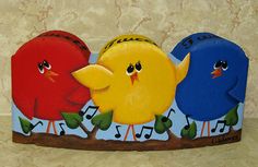 three colorful birds sitting on top of a wooden plaque with music notes in the background