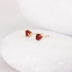 These tiny red and blue sapphire earrings are perfect for a bit of regal sparkle and for second piercings. They feature lovely 3mm sapphire stones that are absolutely stunning and filled with fire - the red Songea sapphire is particularly lovely. The post is centered on the back of the solid 14K gold setting and matching 14K earring backs are included. Reliable and effortless - exactly the kind of sparkle that I love to add to my day. Both varieties of sapphire are natural and genuine. Shop home Red Round Cut Birthstone Earrings, Dainty Red 14k Gold Earrings, Second Piercings, Blue Sapphire Studs, Second Piercing, Sapphire Stones, Sapphire Studs, Mini Studs, Stacked Bangles