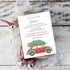 a red car with a christmas tree on the roof is sitting in front of a card