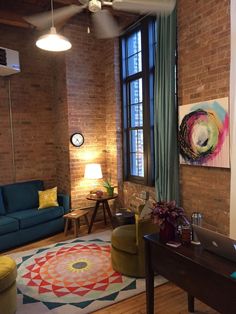 a living room filled with furniture and a flat screen tv mounted to the wall next to a window