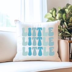 a pillow sitting on top of a couch next to a potted plant