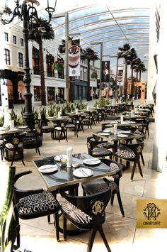 tables and chairs are set up in the middle of an outdoor area with palm trees