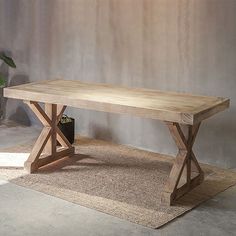 a wooden table sitting on top of a rug next to a potted green plant