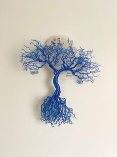 a blue wire tree on a white wall