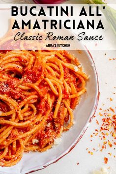 a white plate topped with pasta covered in tomato sauce next to garlic and parmesan cheese