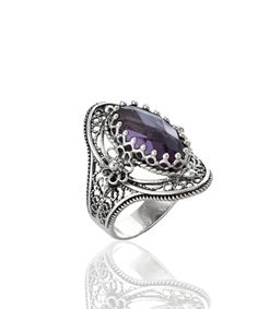 "Beautifully designed and crafted, this Amethyst, Blue Topaz and opaque, dyed Ruby Corundum oval ring is a statement piece. The ring face is made from sterling silver and features a high polished finish that reflects light beautifully. It has beautifully two daisy figures on both sides. It comes in sizes 5 to 12 sizes and has faceted, checkerboard oval-cut gemstones on its top add more beauty to the piece. The high-quality sterling silver used in this design ensures durability, while keeping the Amethyst Cocktail Ring, The Ring Face, Statement Ring Silver, Sterling Silver Filigree, February Birthstone, Purple Stones, February Birth Stone, Silver Filigree, Favorite Rings