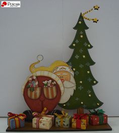 a christmas tree with presents under it next to a santa clause ornament on a shelf