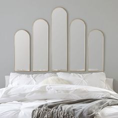 a bed with four mirrors above it on the headboard