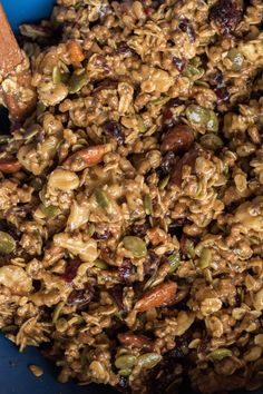 a blue bowl filled with granola and nuts