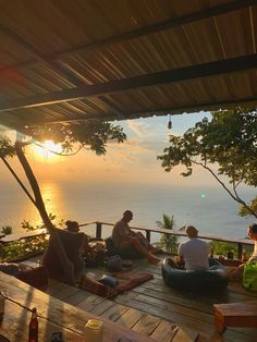 several people sitting on the deck at sunset