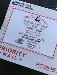 a mail box that is sitting on top of a black tile floor with the letters priority mail written in red and white