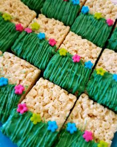 rice krispy treats with green frosting and flowers on them are arranged in the shape of squares