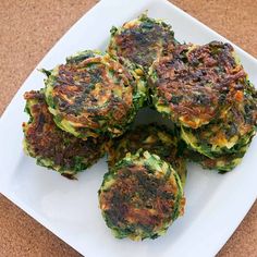 some food is on a white plate on a brown tablecloth and it looks like broccoli fritters