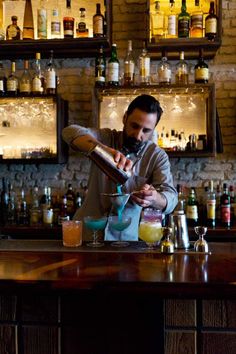 a man is making a drink at the bar